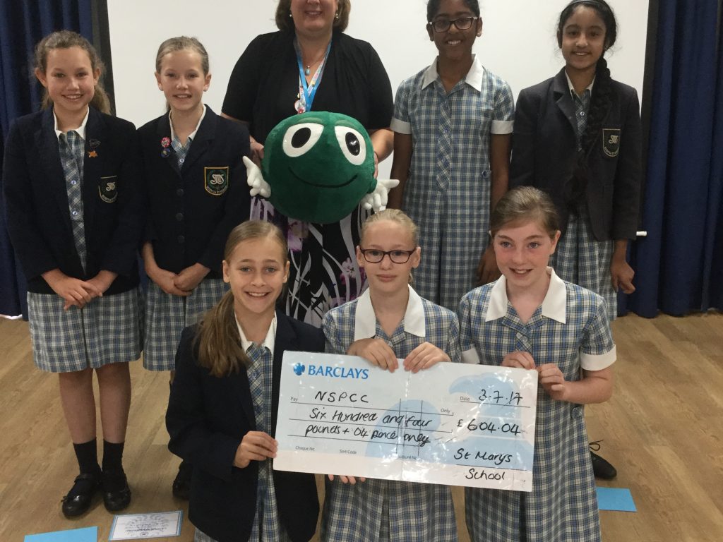 Girls holding NSPCC cheque