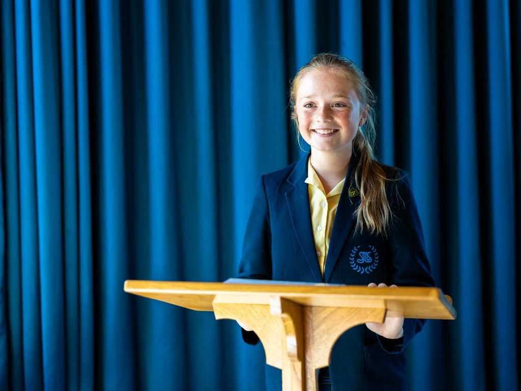 girl standing behind a podium