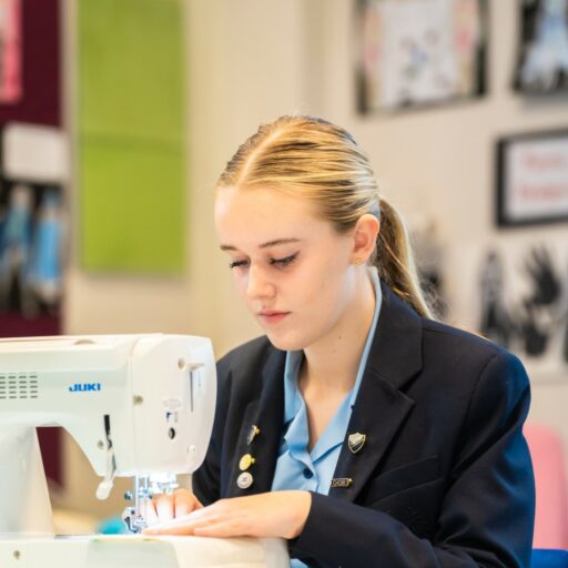 Student using a sewing machine during a fashion and Textiles class at St Mary's Senior School in Essex