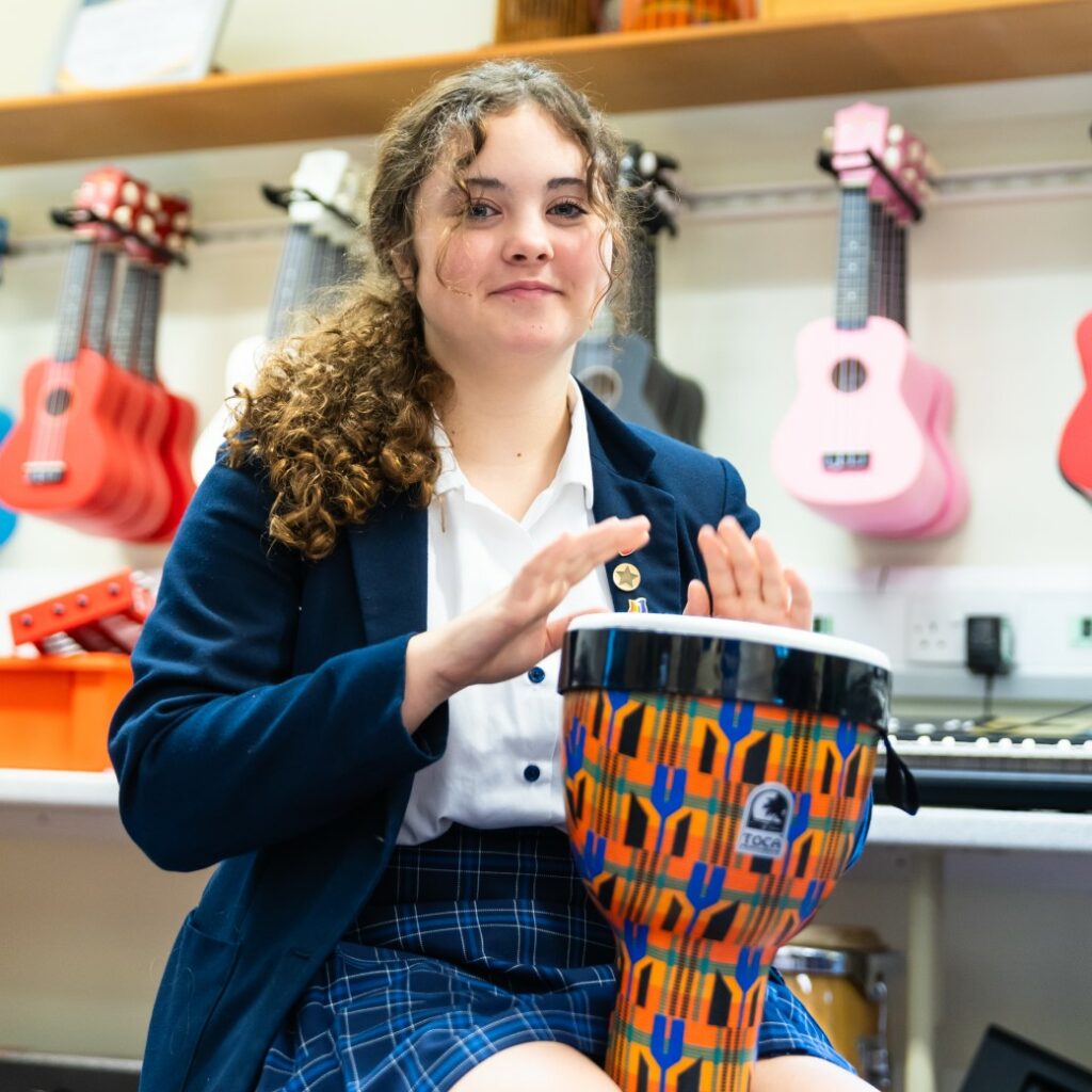 Senior school pupil playing a percussion instrument in a music class at St Mary's Colchester