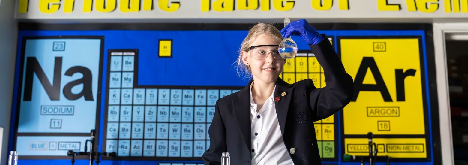 Senior school student in a Science lab at St Mary's Private school, holding a beaker and wearing safety goggles